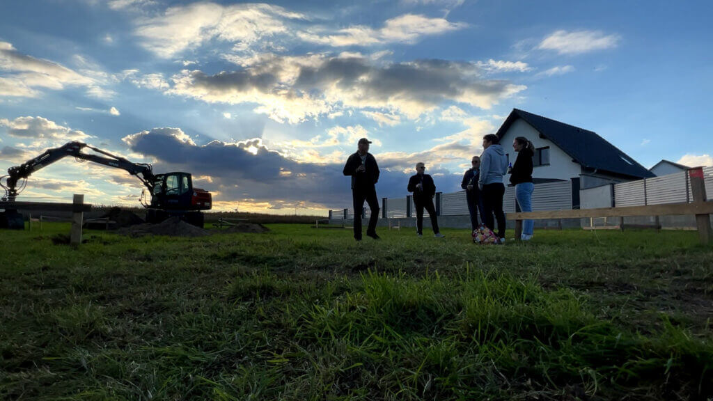 Freunde, Familie, Sarah und Thomas am Austauschen von Eindrücken von dem ersten Bautag. Kühles Blondes beim Sonnenuntergang am Bauplatz