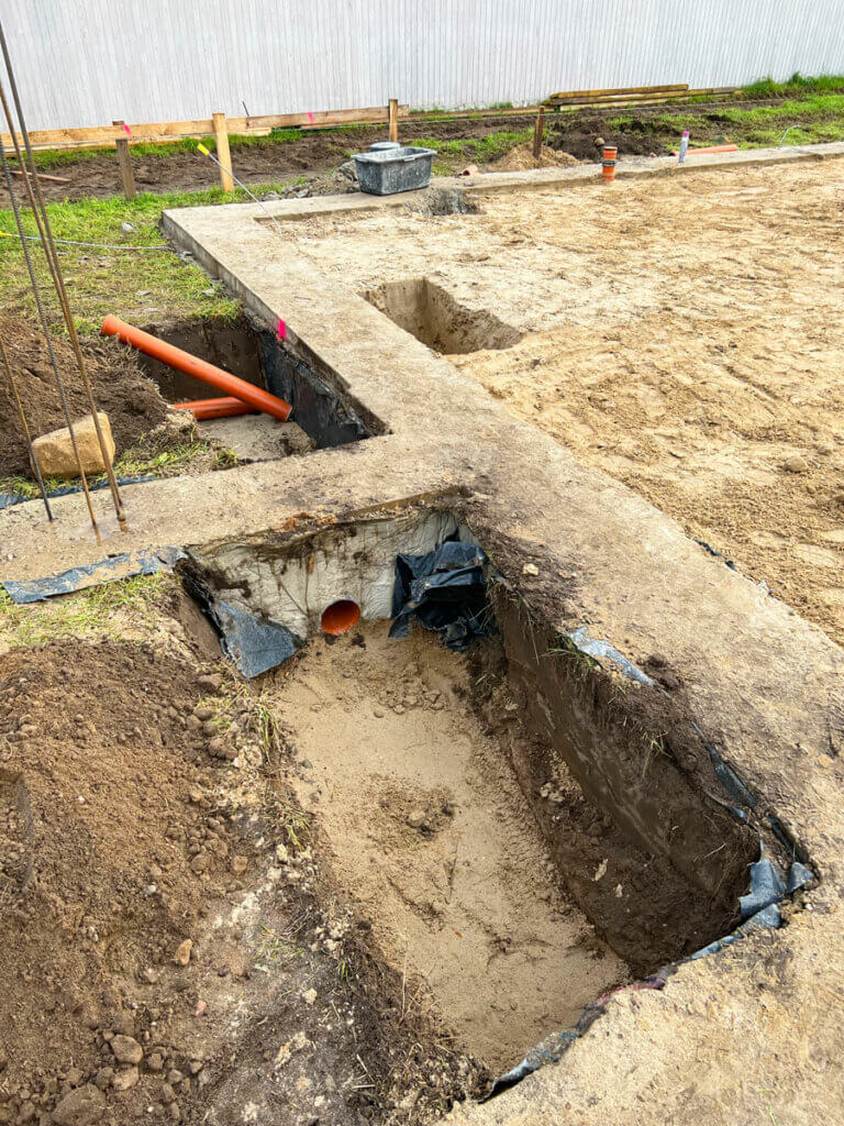 Vorbereitung der Hausentwässerung am 8. Tag. KG-Rohre für Entwässrung bzw. Abfluss im Eingangsbereich.